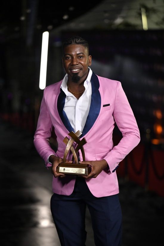 Tyller Jules holding the Gimies award trophy
